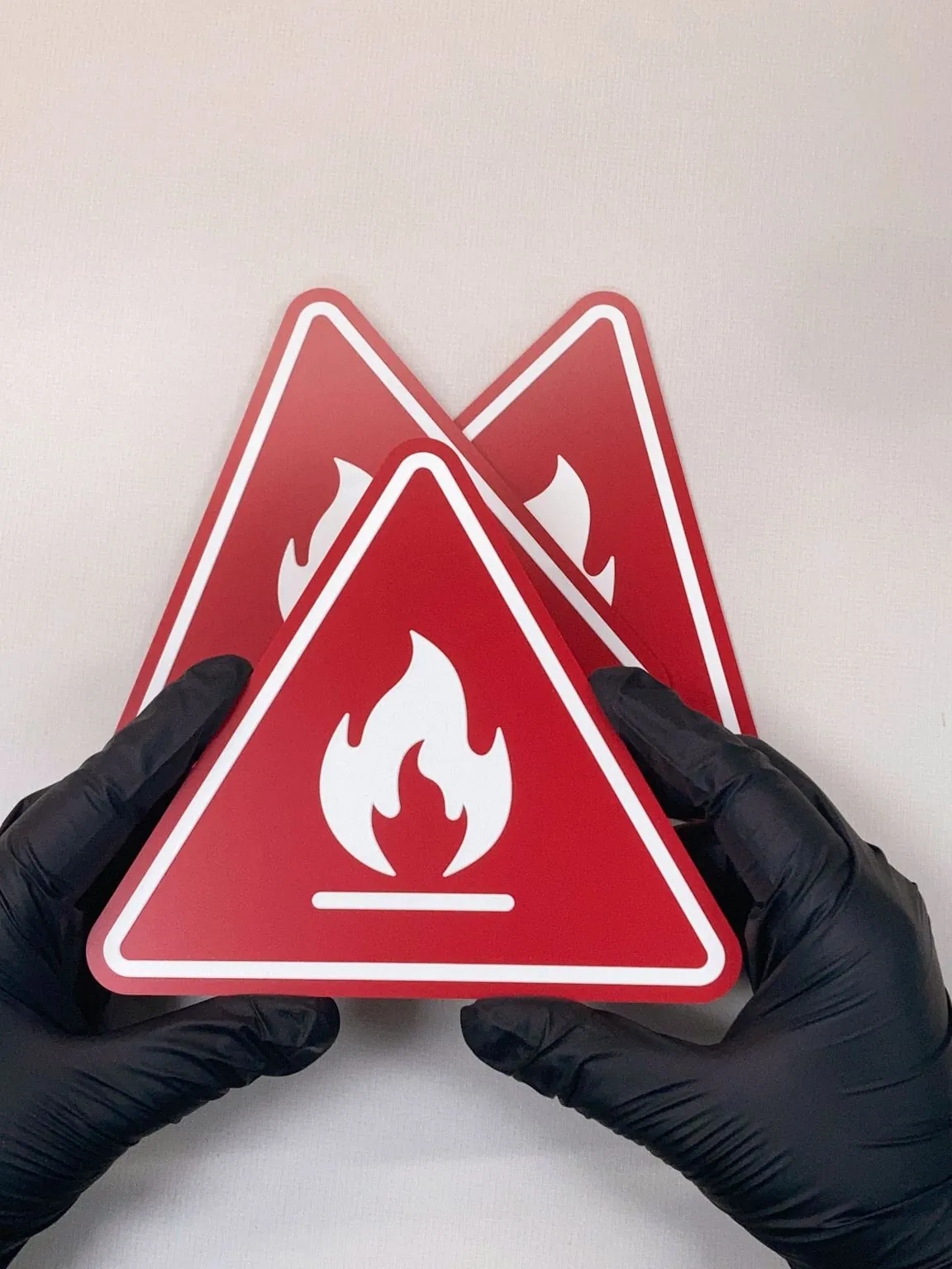 Gloved hands holding etched fire-warning safety plates