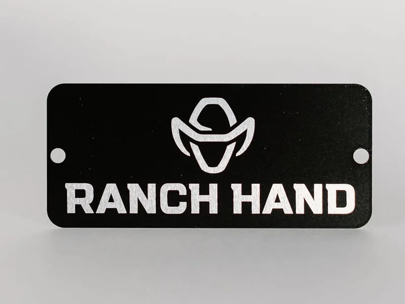 A black aluminum Ranch Hand badge with silver lettering