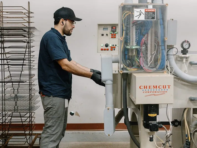 An operator at the Chemcut etch line control station