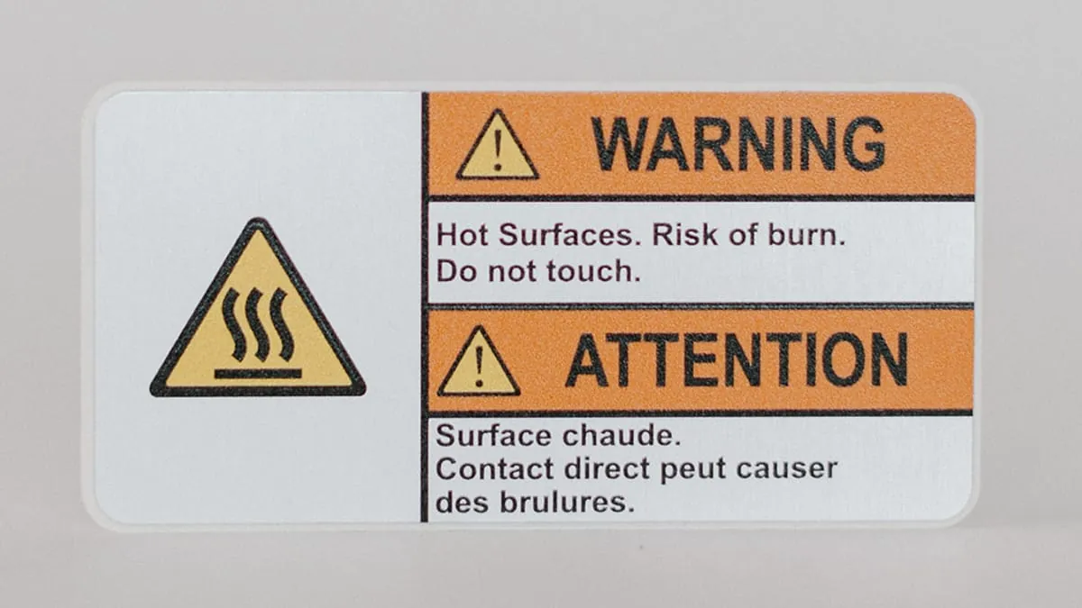 A bilingual hot-surface burn warning decal in English and French