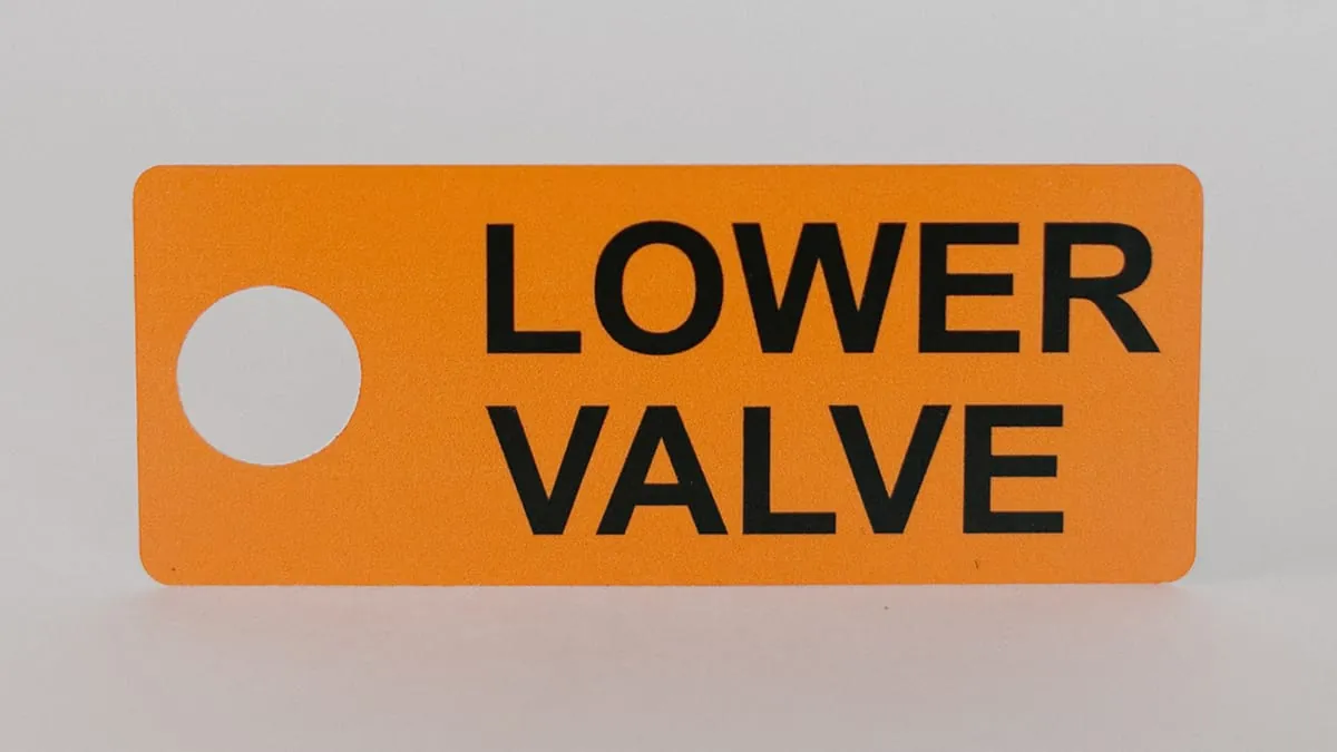 An orange Lower Valve equipment tag with a mounting hole