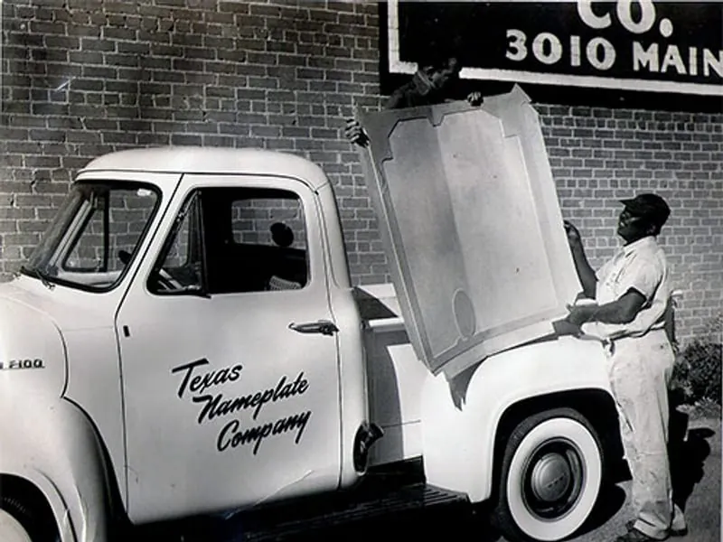 The Texas Nameplate Company delivery truck outside the original shop at 3010 Main St, Dallas