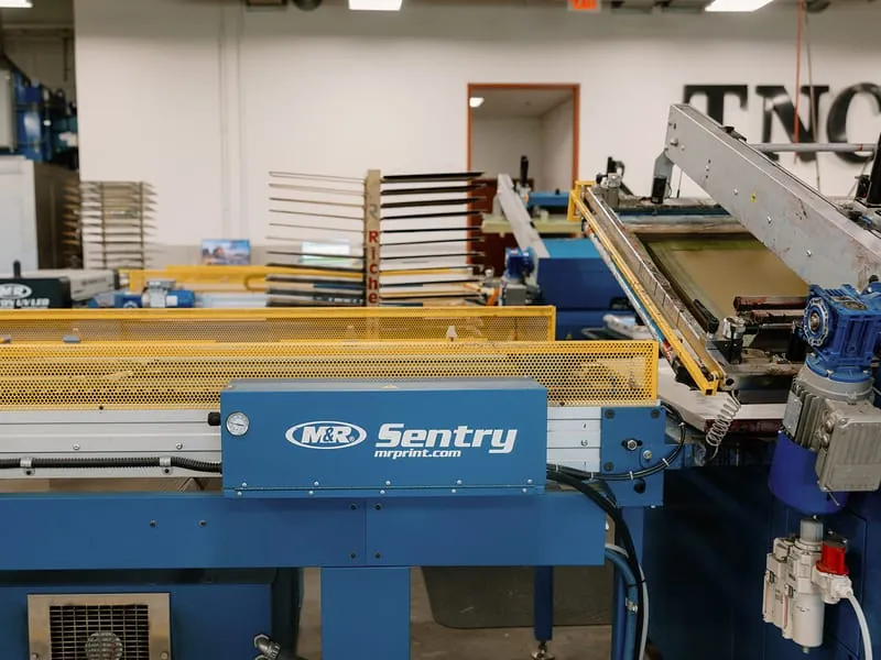 The M&R Sentry screen printing press with its inked screen raised