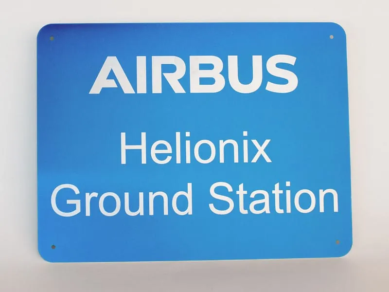 A blue Airbus Helionix Ground Station facility sign